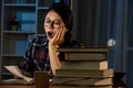 Young student yawning at night with books Royalty Free Stock Photo