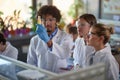 Young students carefully observe a chemical reaction in a test tube in a laboratory. Science, chemicals, lab, people