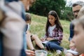 Young students learning about nature, forest ecosystem during biology field teaching class, writing notes. Male teacher Royalty Free Stock Photo