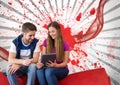 Young students looking at a tablet against white and red splattered background