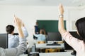 Young students raising hands in a classroom Royalty Free Stock Photo