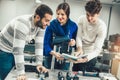 Young students of robotics preparing robot for testing