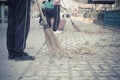 Young students sweeping dried leafs on the floor in school Royalty Free Stock Photo