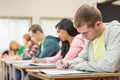 Young students writing notes in classroom Royalty Free Stock Photo