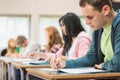 Young students writing notes in classroom Royalty Free Stock Photo