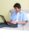 Young studying on the bed with laptop