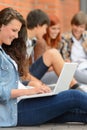 Young studying woman using laptop outside college Royalty Free Stock Photo