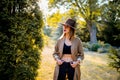 Girl in hat and clothes in a village garden in sunset time