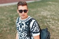 Young handsome man in sunglasses walking with a bag Royalty Free Stock Photo