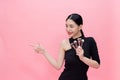 Young Stylish Asian woman carrying makeup brushes on hand with copy space. Beautiful fashionable woman isolated over pink Royalty Free Stock Photo