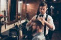 Young stylish bearded guy is in a barber shop, getting brend new