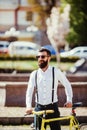 Young stylish bearded man with a fixie bicycle on the sunny street