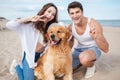 Young stylish beautiful couple in love sitting playing with dog Royalty Free Stock Photo