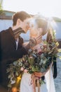 young stylish bride and groom embracing and kissing