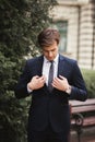 Young stylish businessman adjusting his suit, neck tie Royalty Free Stock Photo