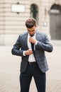 Young stylish businessman adjusting his suit, neck tie Royalty Free Stock Photo