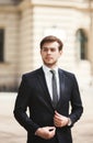 Young stylish businessman adjusting his suit, neck tie Royalty Free Stock Photo