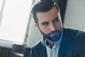 Young stylish businessman leader indoors at office looking aside