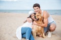 Young stylish couple in love sitting playing with dog Royalty Free Stock Photo