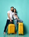 Young stylish couple man and woman in casual clothes are smiling posing with travel yellow suitcases Traveling Royalty Free Stock Photo