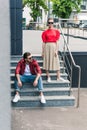 young stylish couple of models in sunglasses on stairs at urban