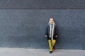 Young stylish cute hippie woman standing against black wall on the street. Millennial hipster girl portrait outdoor, outside of Royalty Free Stock Photo