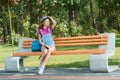 Young stylish dressed girl sitting on the bench keeping a book. Royalty Free Stock Photo