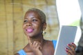 Young stylish and elegant black African American business woman working at trendy coffee shop using digital tablet pad Royalty Free Stock Photo