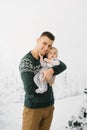 Young stylish father and little son on winter vacation in winter holiday photo zone. The father holds his son in his arms Royalty Free Stock Photo