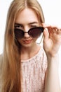 Young stylish girl, model posing with glasses on white background, and winking eyes, for advertising