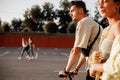 Young stylish guy and girl are walking together on the square for parking on the sunny day Royalty Free Stock Photo