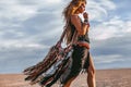 Young stylish hippie woman on the beach at sunset portrait