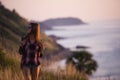 Young stylish hipster girl enjoy sunset on viewpoint. Travel woman with backpack Royalty Free Stock Photo