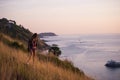 Young stylish hipster girl enjoy sunset on viewpoint. Travel woman with backpack Royalty Free Stock Photo