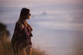 Young stylish hipster girl enjoy sunset on viewpoint. Travel woman with backpack Royalty Free Stock Photo