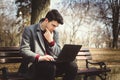 Young stylish male student texting message on laptop Royalty Free Stock Photo