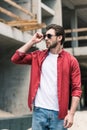 young stylish man adjusting sunglasses at construction Royalty Free Stock Photo