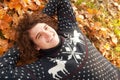 Young stylish man dressed in knit sweater with deers lying on au
