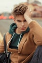 Young stylish man with a haircut in a trendy coat with a hoodie Royalty Free Stock Photo