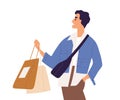 Young stylish man holding shop bags with purchases in hands. Male shopper walking after shopping. Modern customer Royalty Free Stock Photo