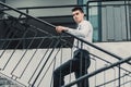 Young stylish man model in classic clothes posing near stairs. Fashion shot