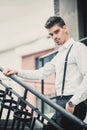 Young stylish man model in classic clothes posing near stairs. Fashion shot Royalty Free Stock Photo