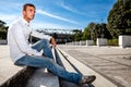 Young stylish man outdoors. Sitting on the steps. Royalty Free Stock Photo