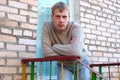 Young stylish man stay on stairs near brick wall. Royalty Free Stock Photo