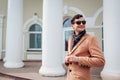 Young stylish man walking in city. Handsome guy wearing classic clothes and accessories. Street fashion Royalty Free Stock Photo