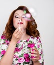 Young stylish red-haired woman with curly hair and pretty face posing and blow bubbles. expresses different emotions Royalty Free Stock Photo