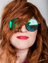 Young stylish red-haired woman with curly hair and pretty face posing in sunglasses. expresses different emotions Royalty Free Stock Photo