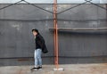 Young stylish redhead man in trendy outfit posing against urban background Royalty Free Stock Photo