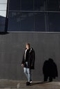 Young stylish redhead man in trendy outfit posing against urban background Royalty Free Stock Photo