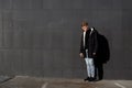 Young stylish redhead man in trendy outfit posing against urban background Royalty Free Stock Photo